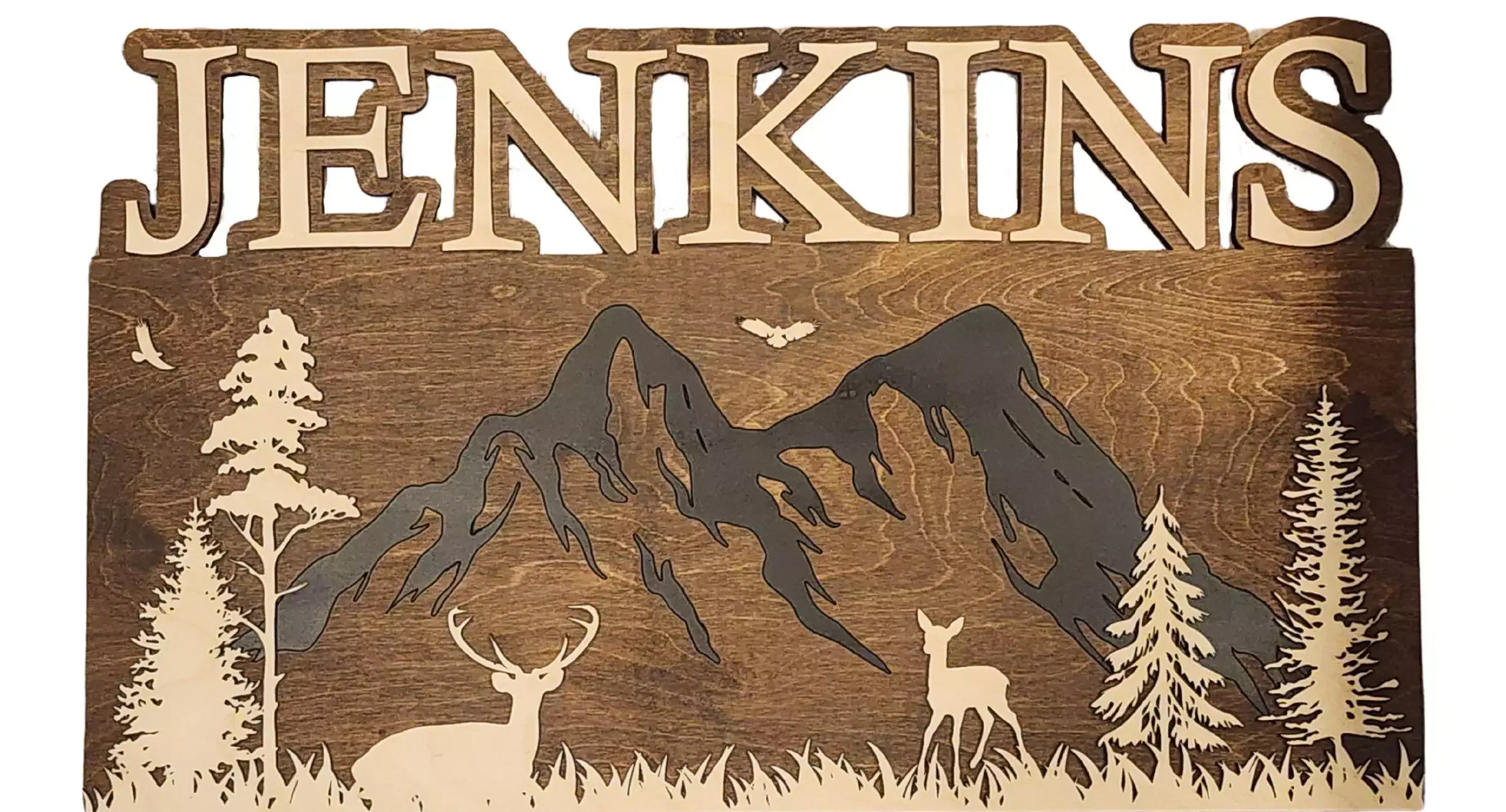 A rustic name sign featuring a forest scene